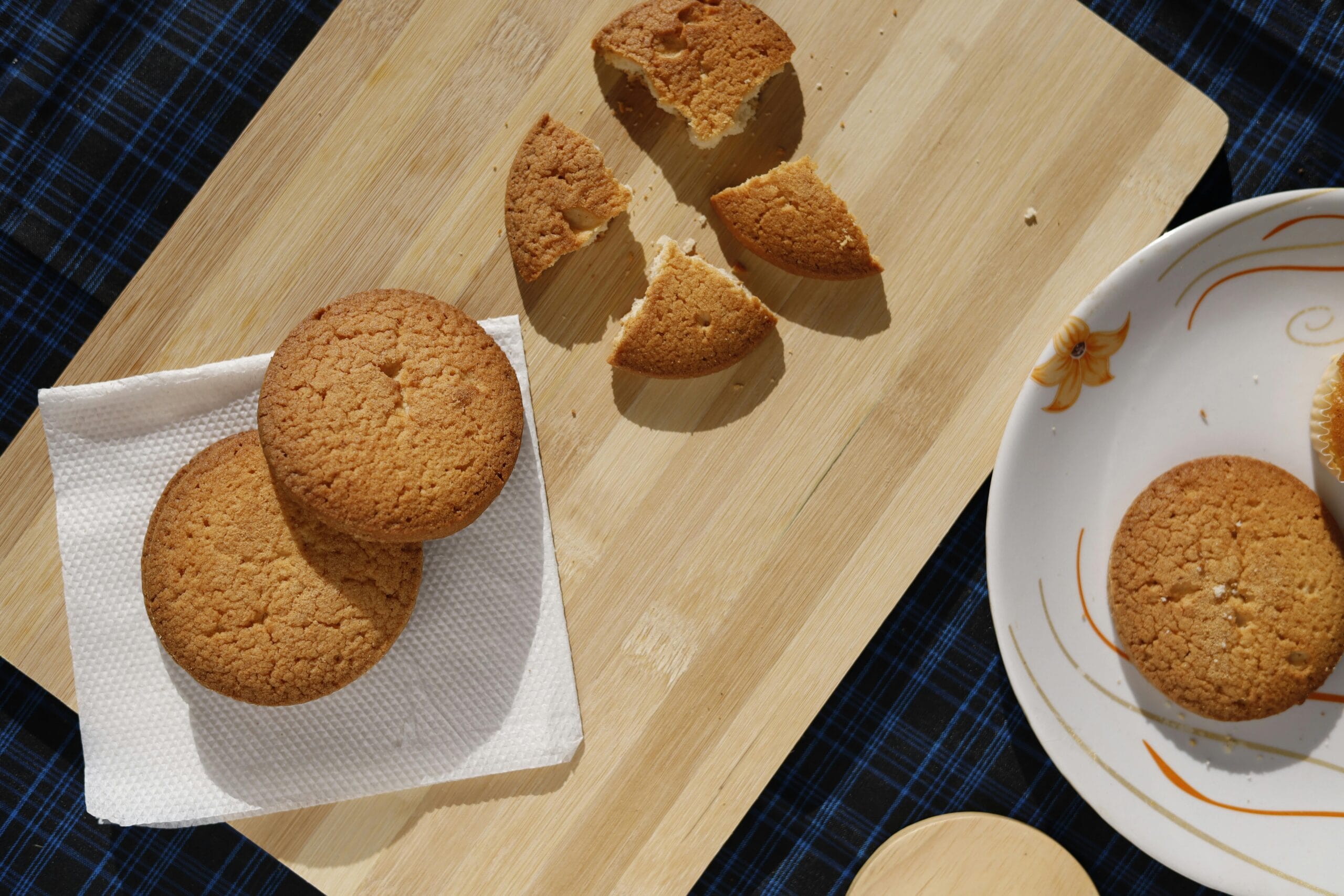 Overhead shot of homemade cookies on wooden board and plate, perfect for dessert enthusiasts.