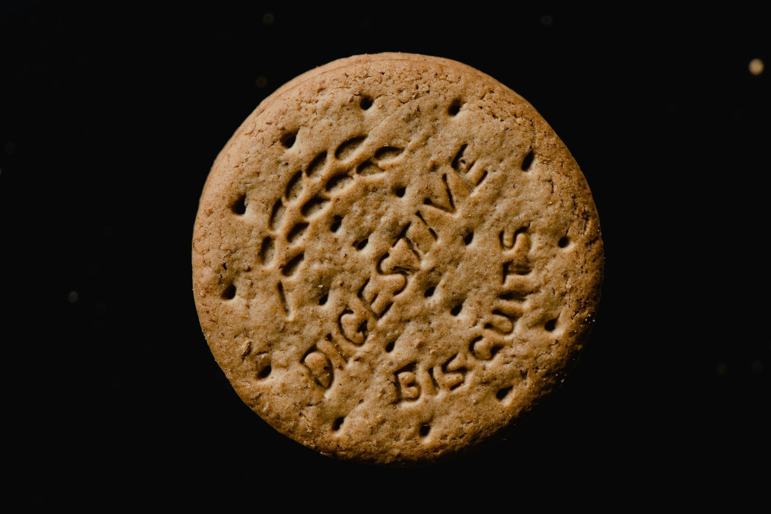 High-resolution image of a round digestive biscuit on a black background, perfect for food-related content.