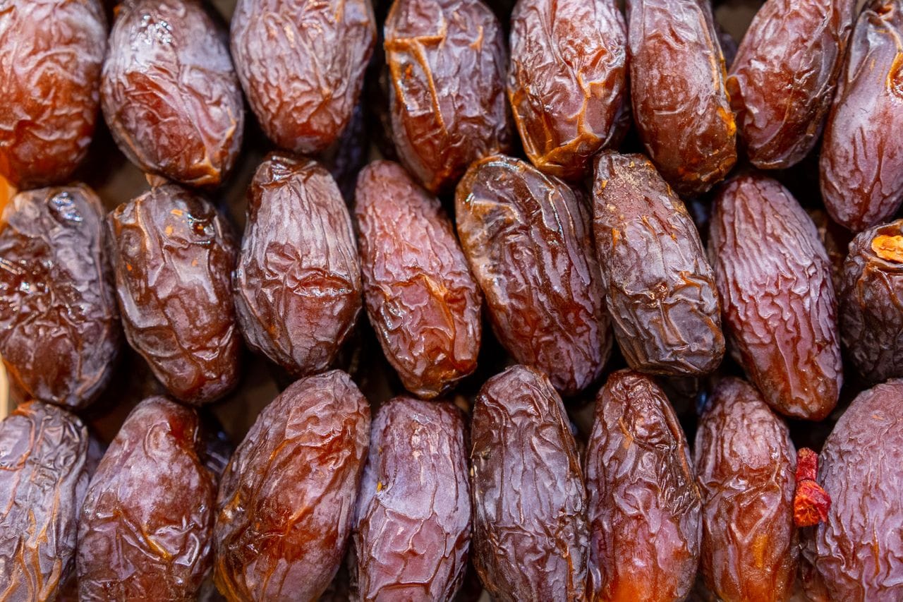 Detailed shot of fresh ripe dates in rows, ideal for food and health topics.