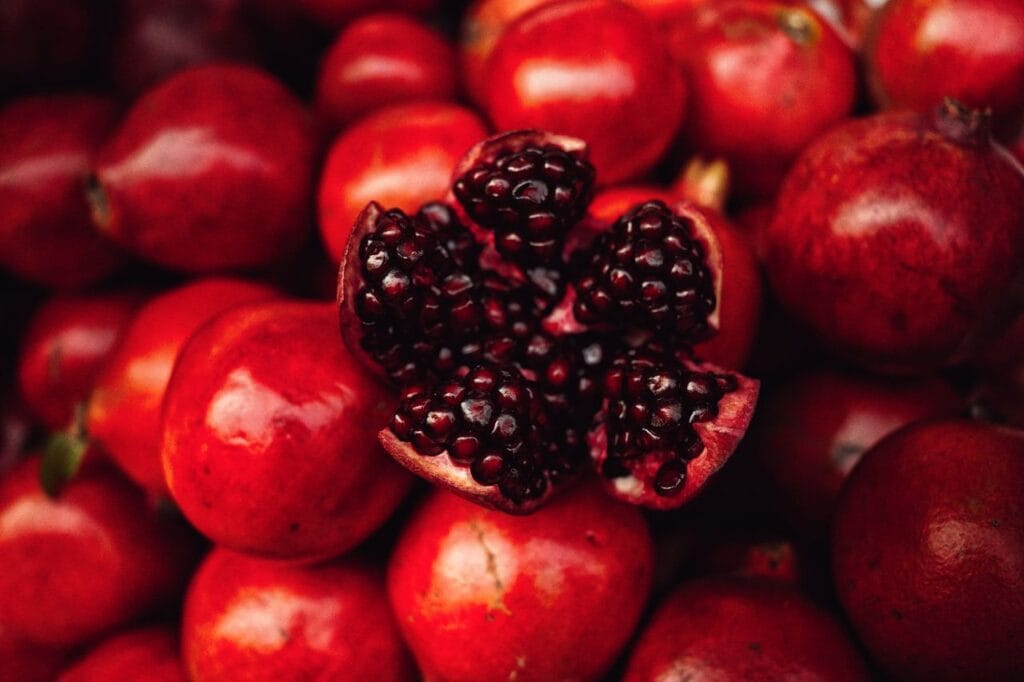Fresh pomegranates vividly captured in a market setting.